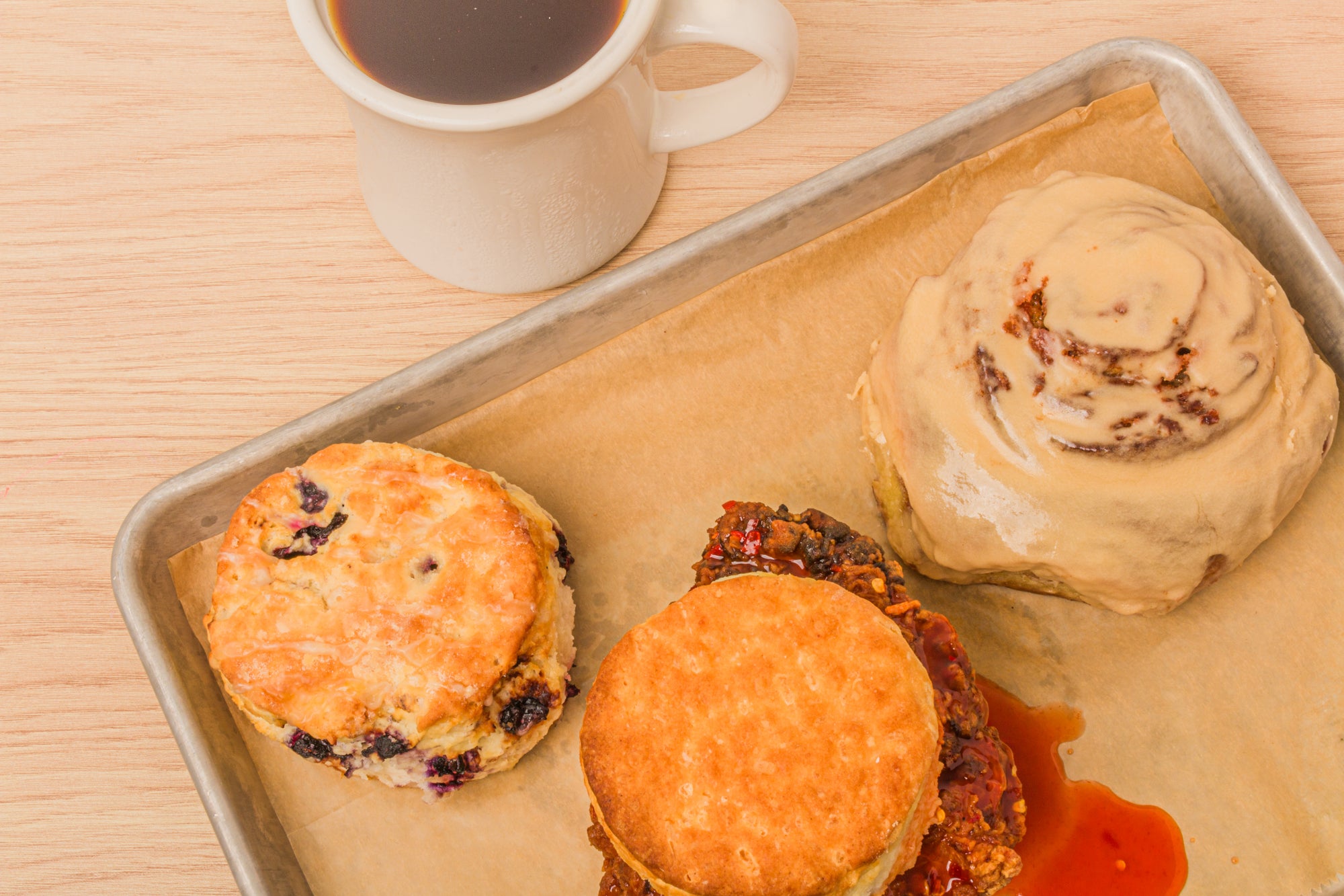 Krankies Coffee's Classic Biscuit breakfast sandwich, Blueberry Biscuit, and Espresso Cinnamon Roll on a tray